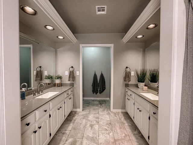 bathroom featuring a sink, two vanities, and visible vents