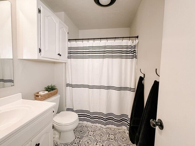 full bathroom featuring vanity, a shower with shower curtain, tile patterned floors, and toilet