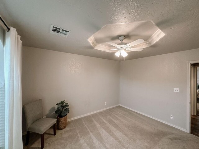 unfurnished room with visible vents, a textured ceiling, baseboards, and light colored carpet