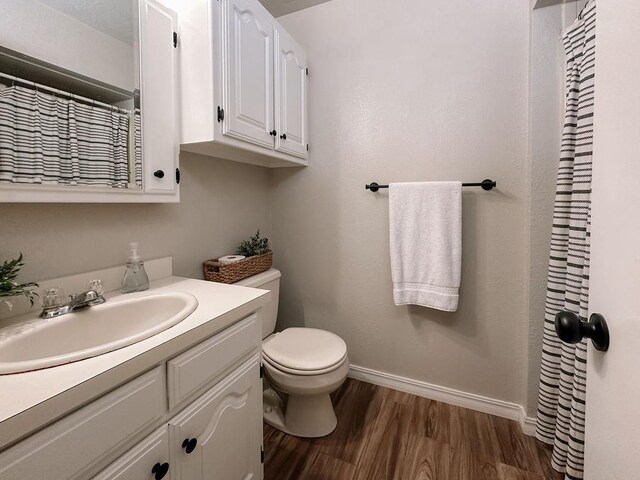 full bath with vanity, wood finished floors, toilet, baseboards, and a shower with shower curtain