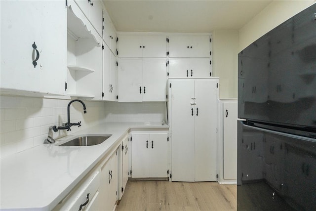 624 SW 44th St, Oklahoma City, OK 73109 - kitchen featuring decorative backsplash, open shelves, a sink, light wood finished floors, and white cabinetry