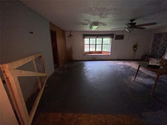 unfurnished living room with concrete flooring and a ceiling fan