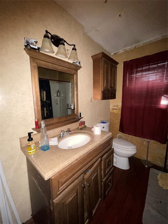 bathroom featuring wood finished floors, vanity, toilet, a shower with shower curtain, and a textured wall