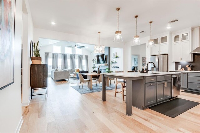 kitchen featuring light countertops, light wood finished floors, ceiling fan, and stainless steel appliances
