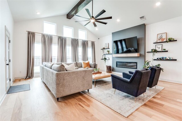 living room featuring visible vents, beamed ceiling, ceiling fan, high vaulted ceiling, and light wood-type flooring