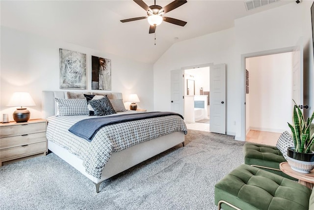 carpeted bedroom with a ceiling fan, vaulted ceiling, connected bathroom, and visible vents