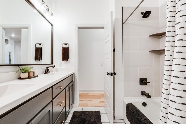bathroom featuring double vanity, a sink, tile patterned flooring, and shower / tub combo