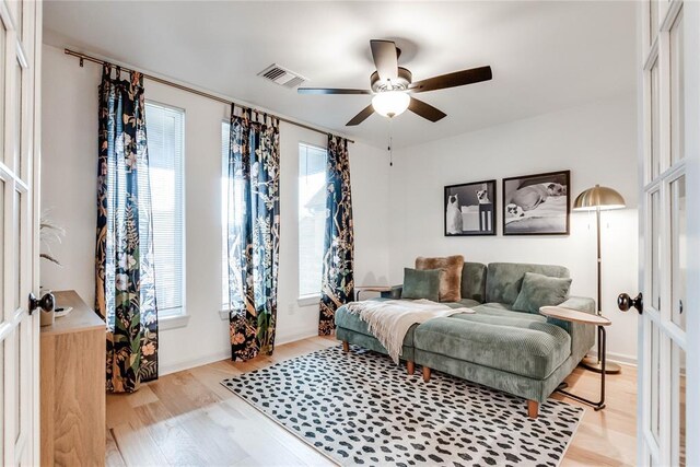 living area featuring visible vents, ceiling fan, and light wood-type flooring