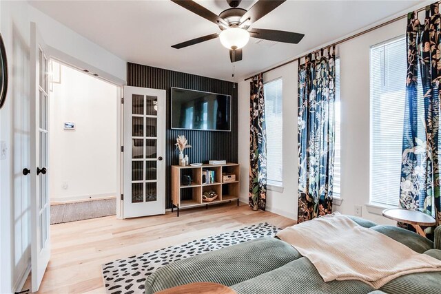 living room featuring french doors, a ceiling fan, baseboards, and wood finished floors
