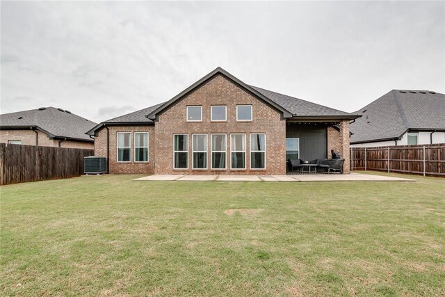 rear view of property with a fenced backyard, a yard, a patio area, and brick siding