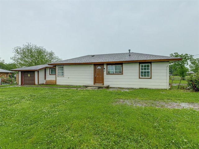 rear view of house featuring fence and a yard