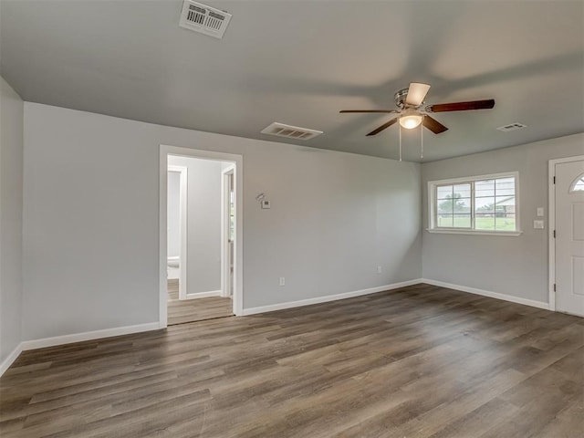 interior space with baseboards, a ceiling fan, and visible vents