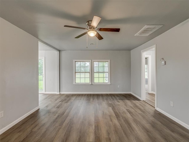 unfurnished room featuring dark wood finished floors, ceiling fan, and a healthy amount of sunlight