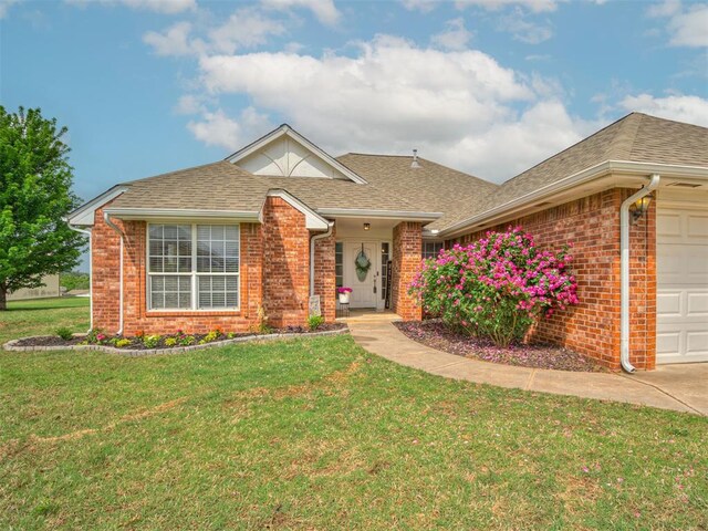 ranch-style house with brick siding, a shingled roof, a front lawn, and a garage