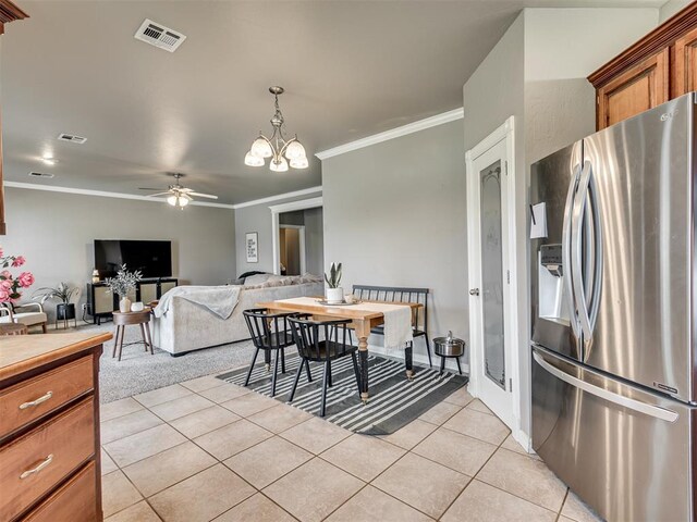 dining room featuring light tile patterned floors, ornamental molding, ceiling fan with notable chandelier, and visible vents