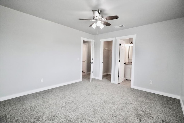 unfurnished bedroom featuring carpet, baseboards, a spacious closet, and a closet