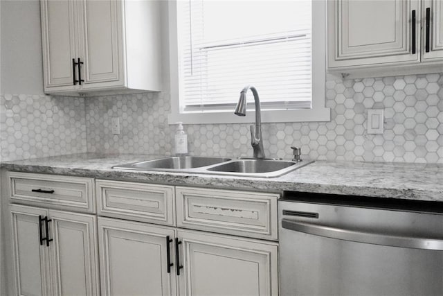 kitchen featuring dishwasher, a sink, light countertops, and decorative backsplash