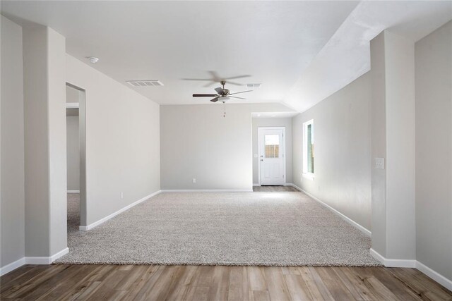 empty room with baseboards, ceiling fan, wood finished floors, and visible vents