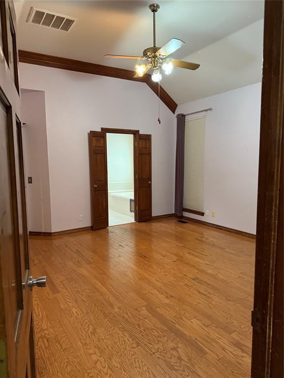 3900 Chickasha, Edmond, OK 73013 - unfurnished room with a ceiling fan, visible vents, lofted ceiling, and light wood-type flooring