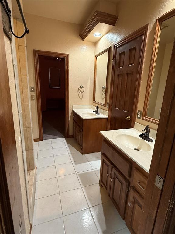 3900 Chickasha, Edmond, OK 73013 - full bathroom featuring a sink, tile patterned floors, a textured wall, and two vanities