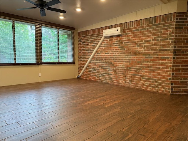 3900 Chickasha, Edmond, OK 73013 - unfurnished room featuring a ceiling fan, brick wall, wood finished floors, and a wall mounted air conditioner