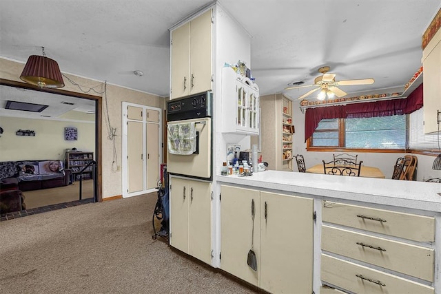 kitchen with ceiling fan, light colored carpet, light countertops, baseboards, and white oven