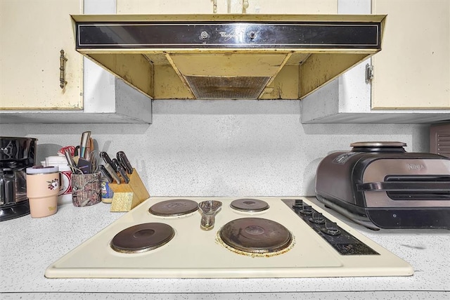 details featuring light countertops, under cabinet range hood, and stove