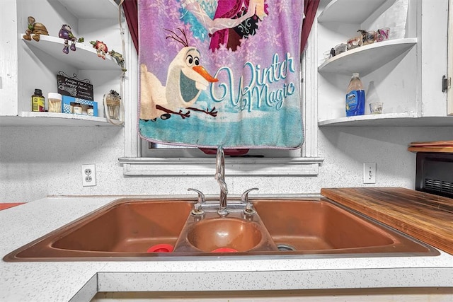 interior details featuring open shelves, a sink, and light countertops