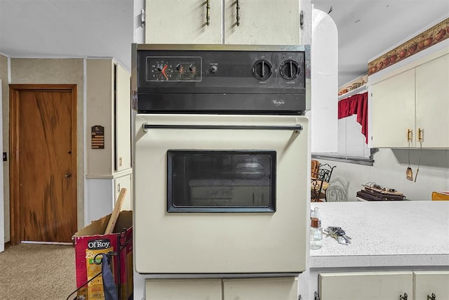 interior details with carpet floors, oven, and light countertops