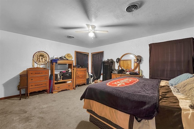 bedroom featuring ceiling fan, carpet flooring, a textured wall, and visible vents