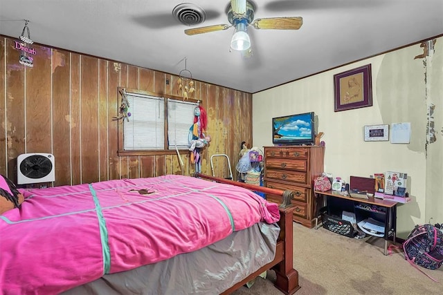 bedroom featuring visible vents, wood walls, carpet, and a ceiling fan