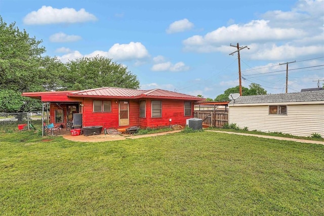 back of house with central air condition unit, a yard, and a fenced backyard