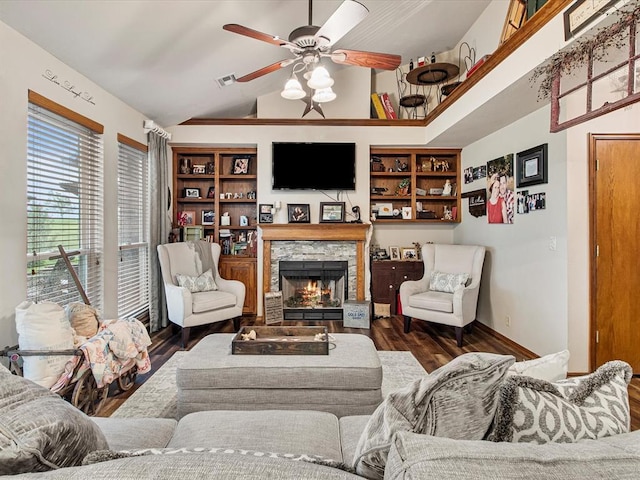living area with ceiling fan, visible vents, a fireplace, vaulted ceiling, and wood finished floors