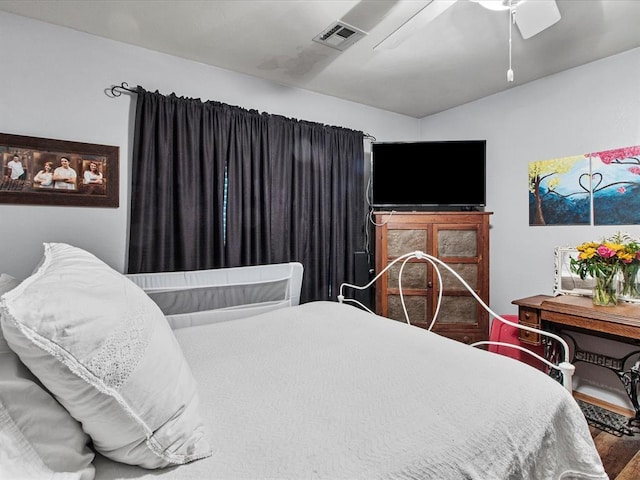 bedroom with visible vents, a ceiling fan, and wood finished floors