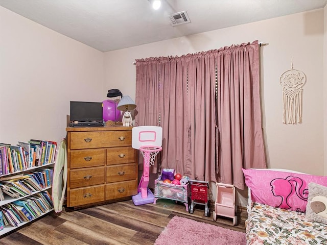 bedroom with visible vents and wood finished floors
