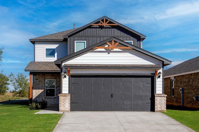 view of front facade with a garage, roof with shingles, a front yard, and concrete driveway