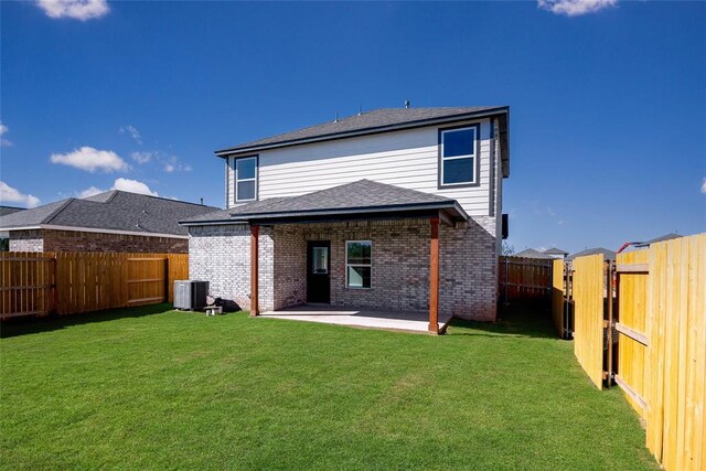 rear view of property with cooling unit, a fenced backyard, brick siding, a patio area, and a lawn