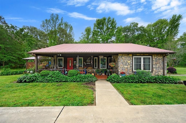 view of front of house with a porch, metal roof, stone siding, and a front lawn
