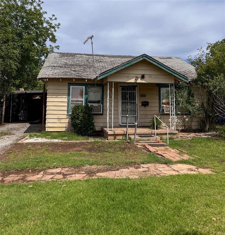 bungalow-style house featuring covered porch and a front yard