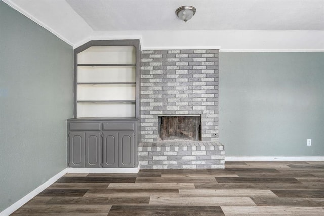 1824 David Ter, Oklahoma City, OK 73141 - unfurnished living room with vaulted ceiling, a brick fireplace, baseboards, and dark wood-style floors