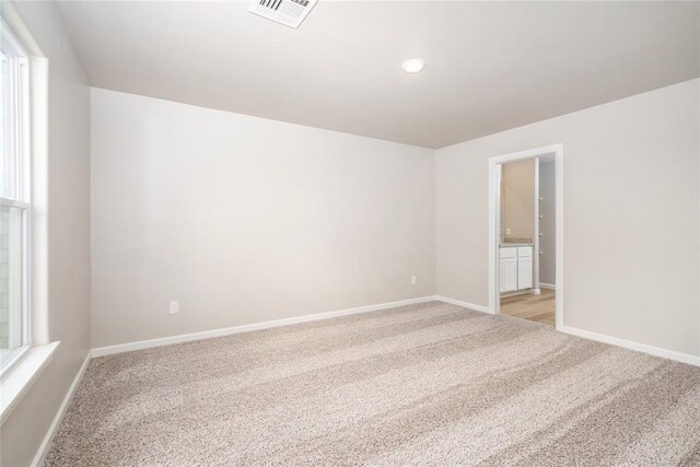 empty room featuring baseboards, light carpet, recessed lighting, and visible vents