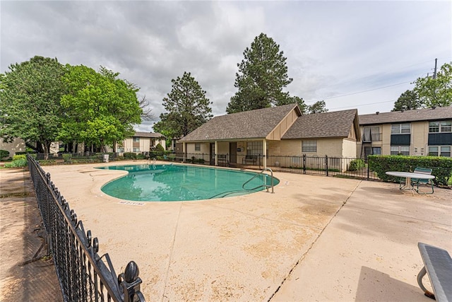 pool with a patio and fence