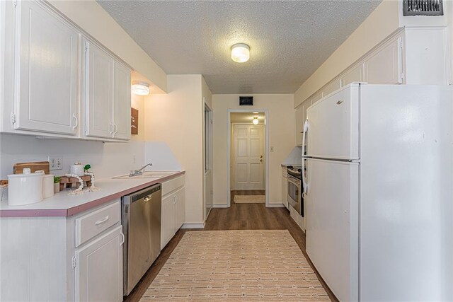 kitchen featuring visible vents, a sink, white cabinetry, and appliances with stainless steel finishes