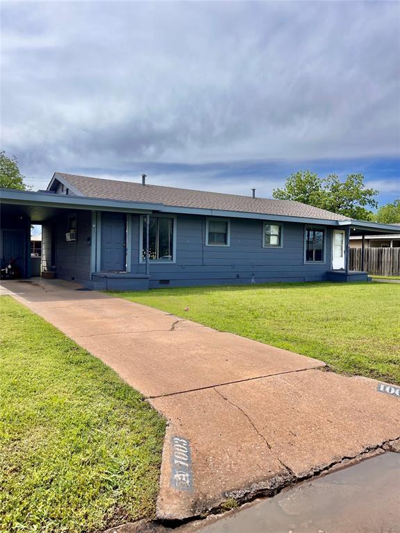 ranch-style home with a carport, driveway, and a front lawn