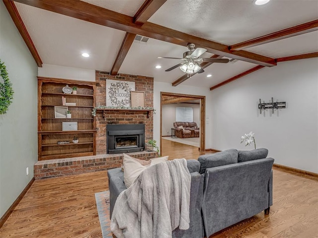 living room with baseboards, ceiling fan, a fireplace, and wood finished floors