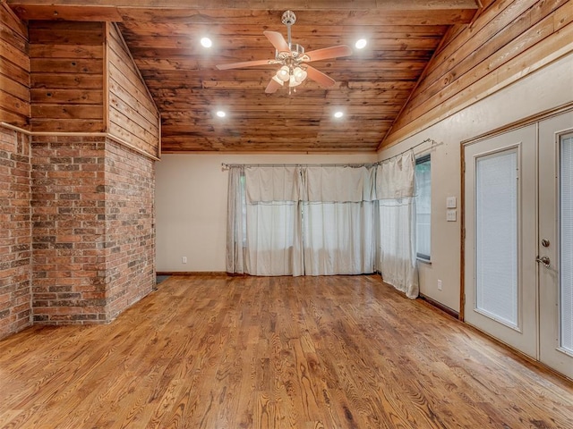 spare room featuring wood finished floors, lofted ceiling, baseboards, wood ceiling, and a ceiling fan