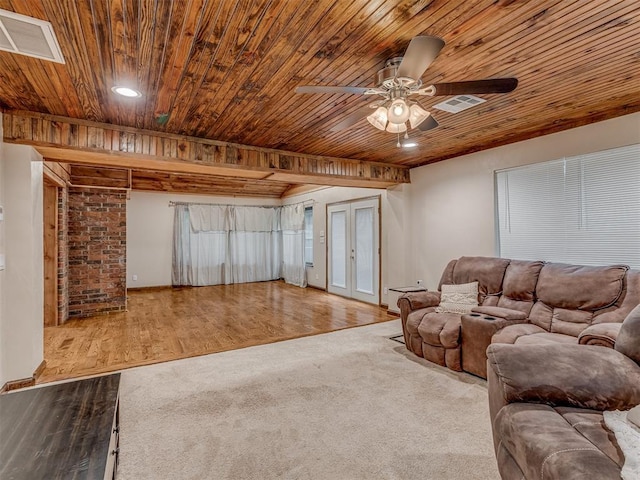 living room with a ceiling fan, visible vents, wooden ceiling, and wood finished floors