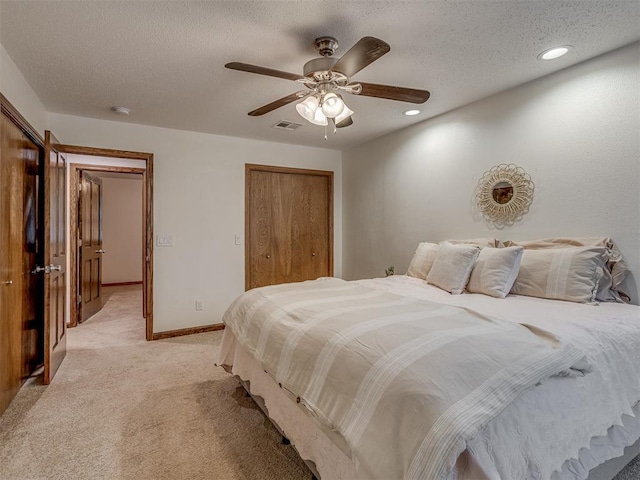 bedroom featuring recessed lighting, a textured ceiling, light carpet, and a closet