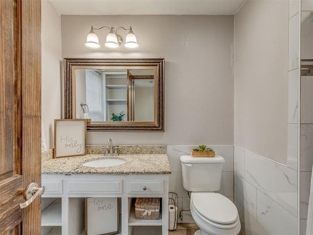 bathroom with vanity, wainscoting, and toilet