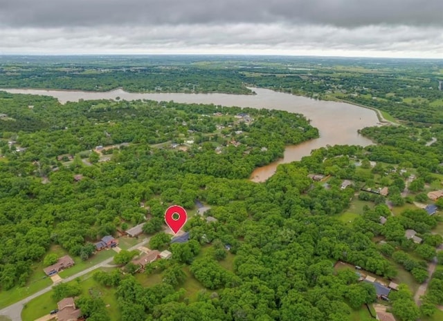 drone / aerial view featuring a water view and a wooded view